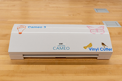 Cameo silhouette vinyl cutter sitting on a wooden table