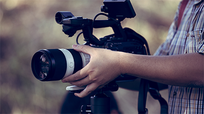 Person holding a camera lenses to get it into focus or position