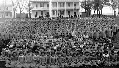 black and white photo of children in front of a large plantation-like house