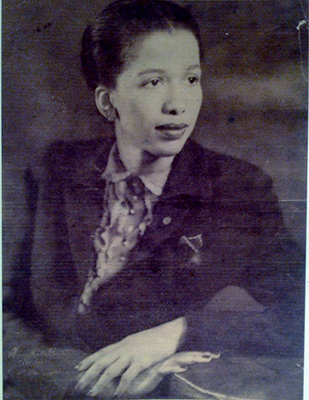 Black and white photo of a younger child in a suit and dress shirt peering off to the right