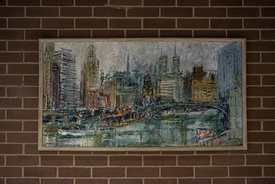Oil painting of the Chicago River hung up on a brick wall