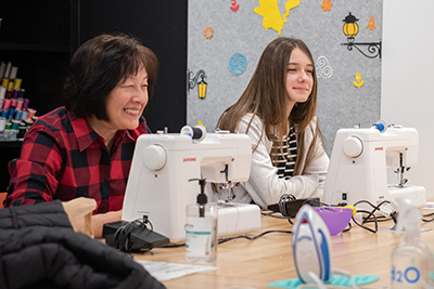 Two people learning how to sew at the library