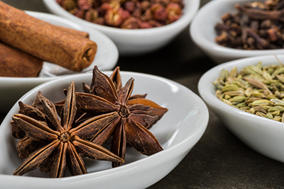 Star Anise and Five Spice in White Spoons with anise in foreground" title="Star Anise and Five Spice in White Spoons with anise in foreground