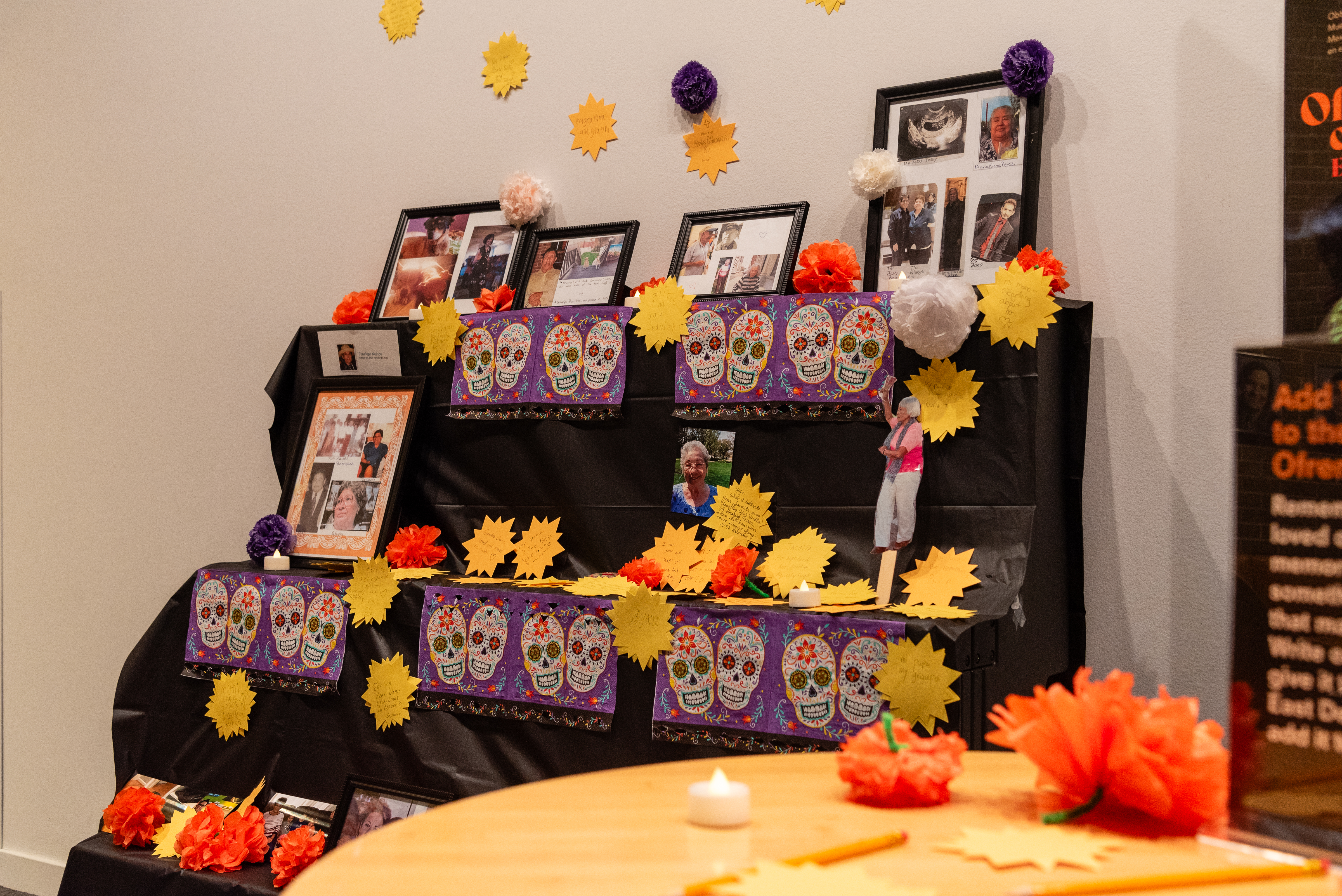 an ofrenda or altar covers in paper marigolds and photos