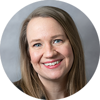 Photo of a woman smiling with a grey background