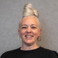 Smiling woman with hoop earrings and a black shirt