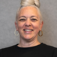 Smiling woman with hoop earrings and a black shirt