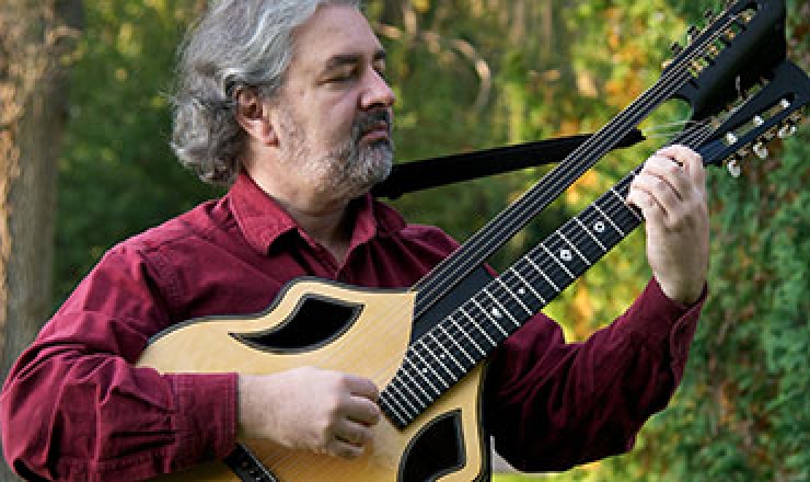 a man is outdoors playing a seven-string guitar