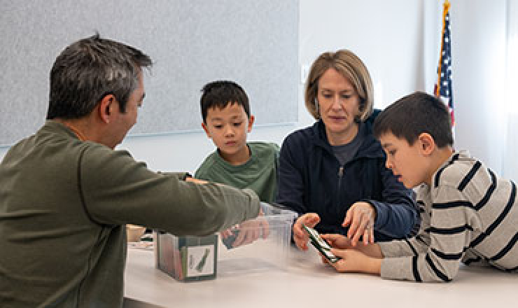 a family of four putting seeds into packets