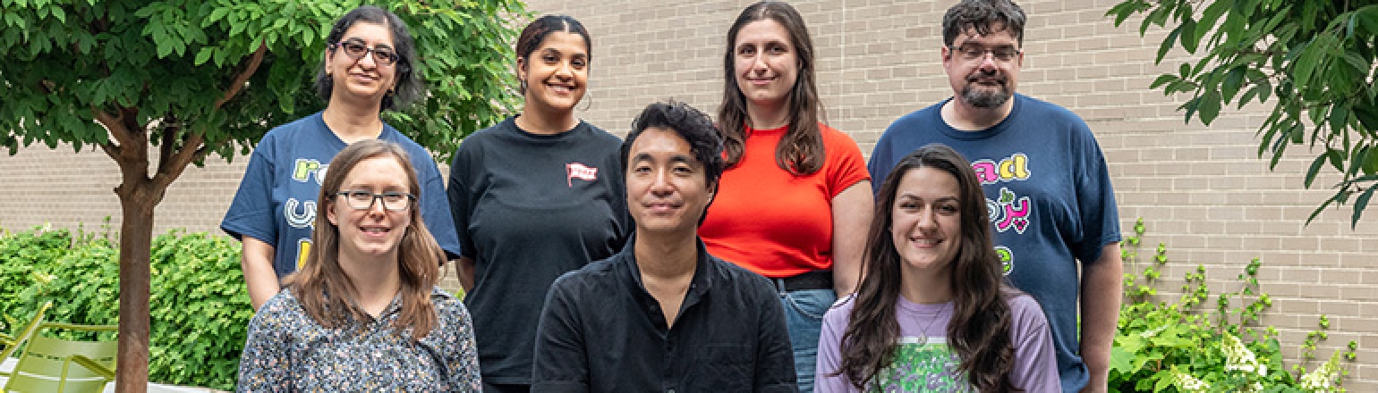 a group of seven people outdoors smiling and looking at the camera