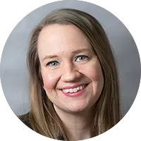 Photo of a woman smiling with a grey background
