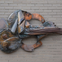 Abstract wall sculpture made from welded bronze, copper, and steel gasket forms.