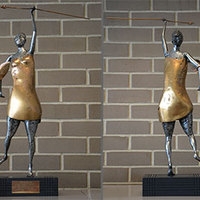 Cast steel and bronze sculpture of a woman with a shield and spear.