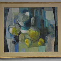 Oil painting in blues and yellows of a still life with bottles and fruit. Signed on the top left.