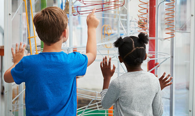 Boy and girl looking at a science sculpture