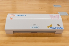 Cameo silhouette vinyl cutter sitting on a wooden table